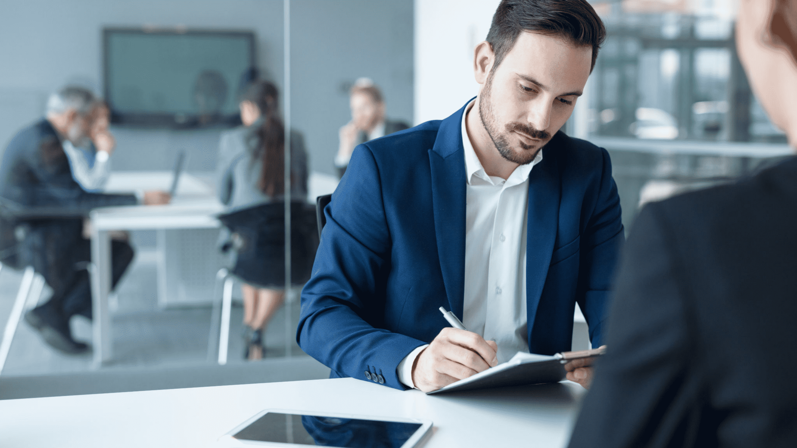 Personne en réunion prenant des notes