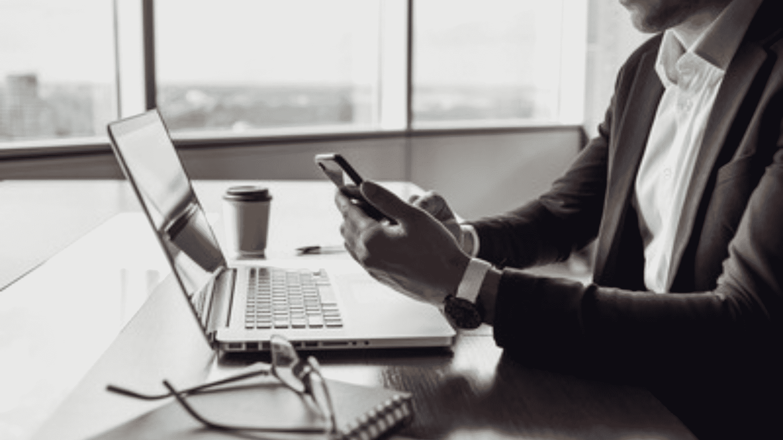 Homme devant son ordinateur portable et son téléphone