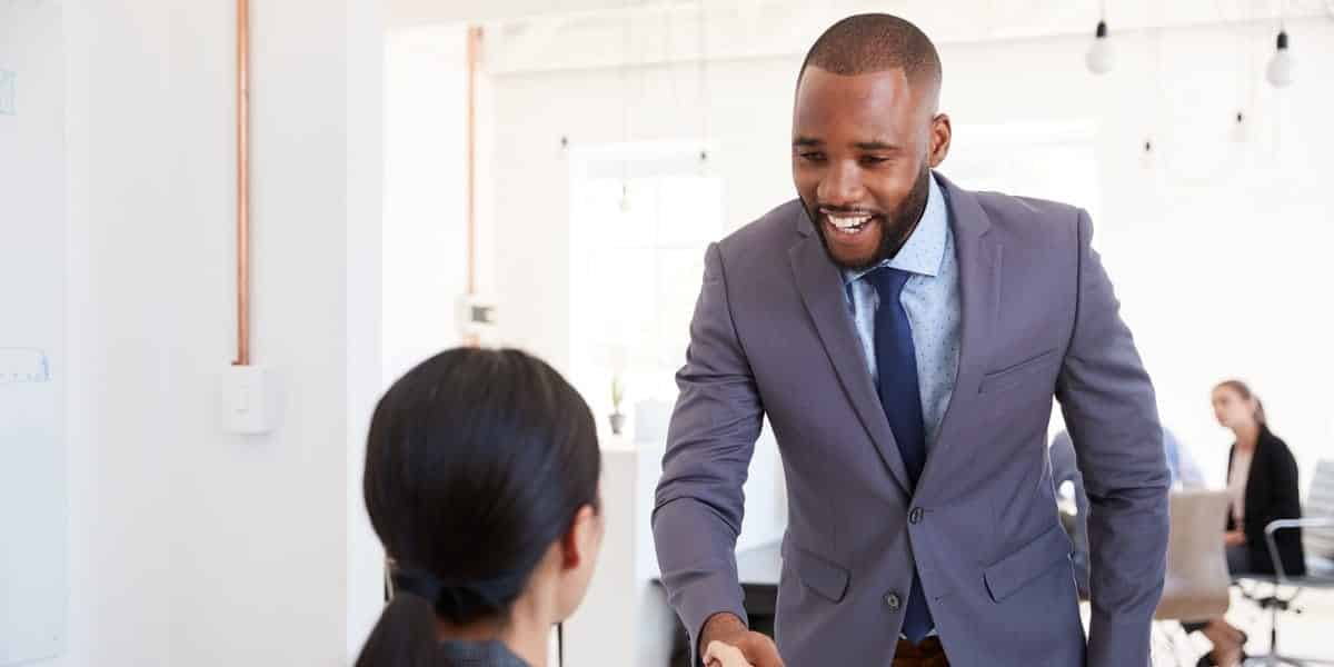 Candidat serrant la main à une recruteuse avant un entretien de recrutement
