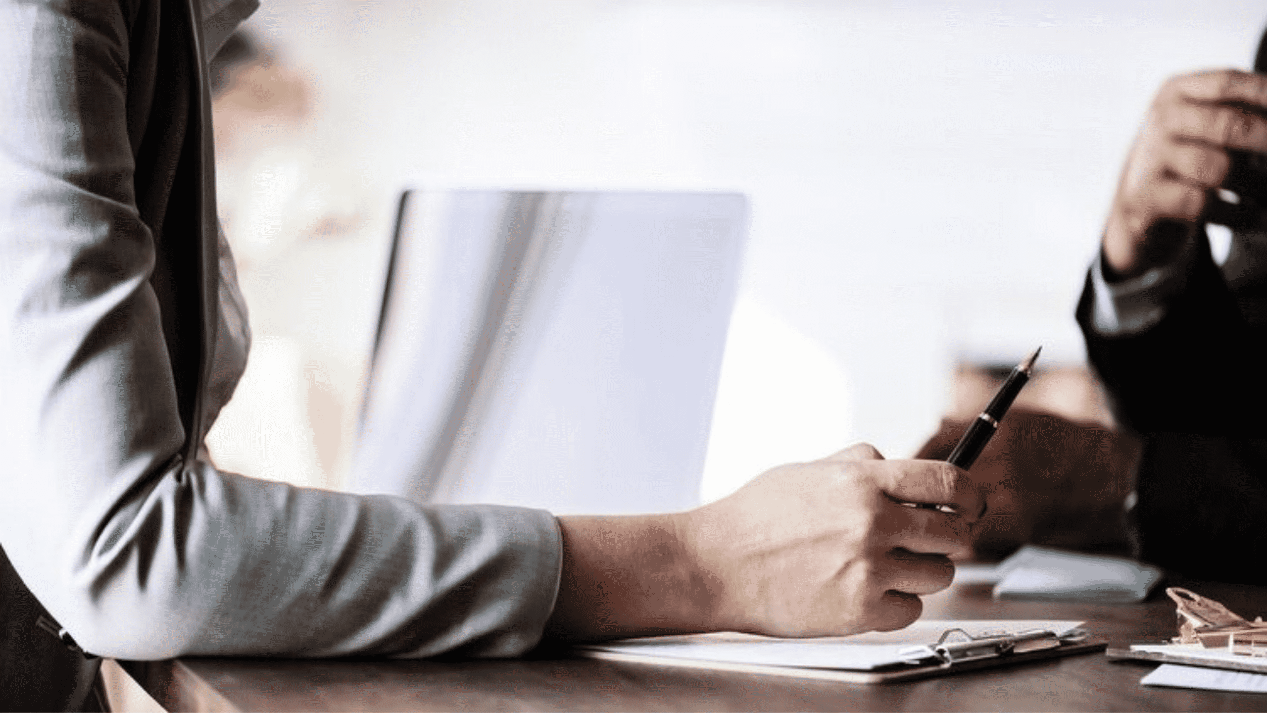 Mains d'un recruteur parcourant un CV avec un stylo à la main pour corriger les erreurs.