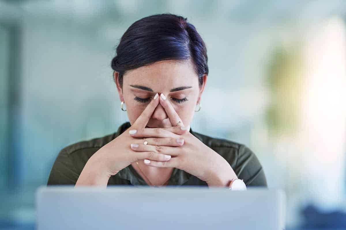 Femme triste et pensante devant son ordinateur