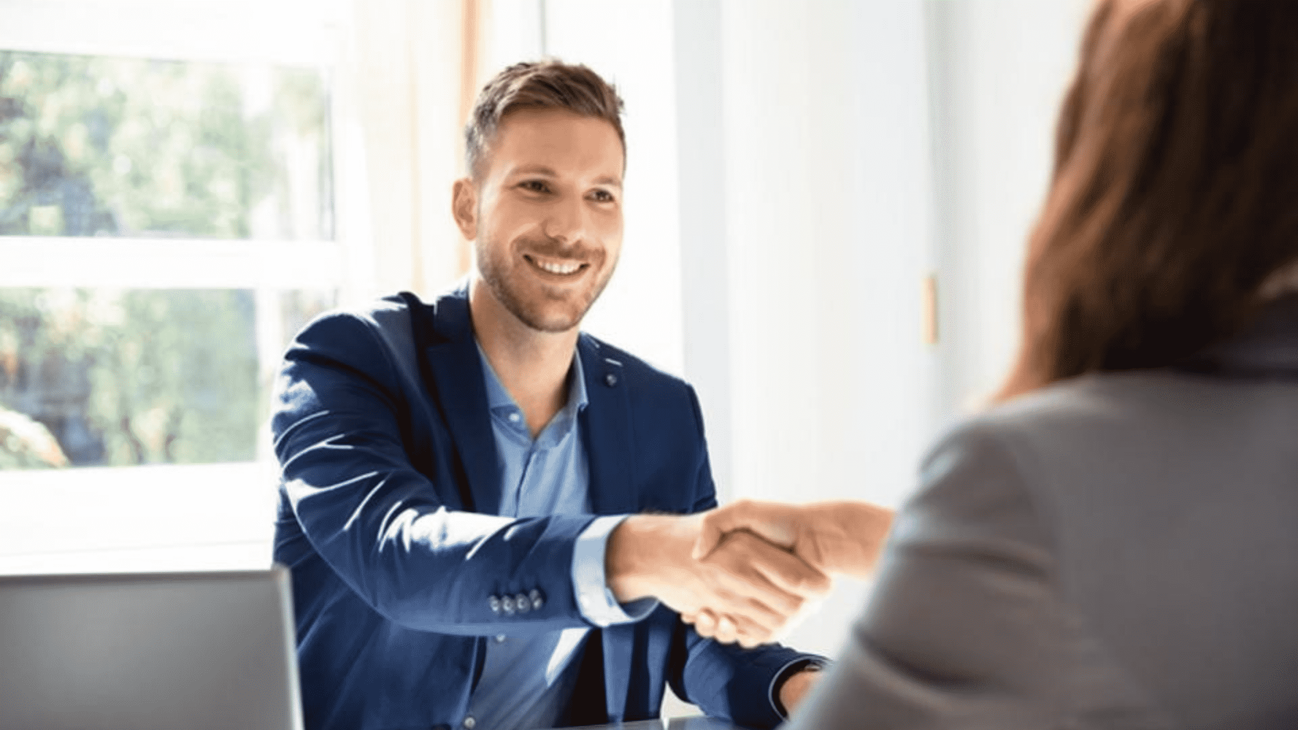 Un recruteur serrant la main à une candidate