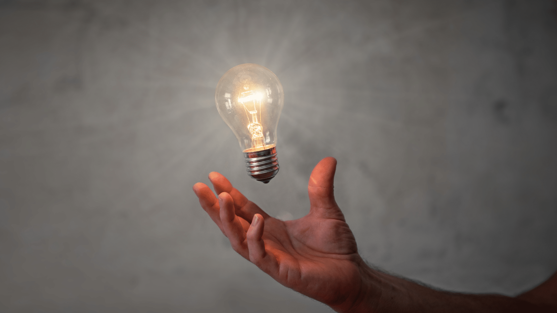 Main qui tient une ampoule allumée pour représenter les tendances innovations pour 2024 dans le recrutement