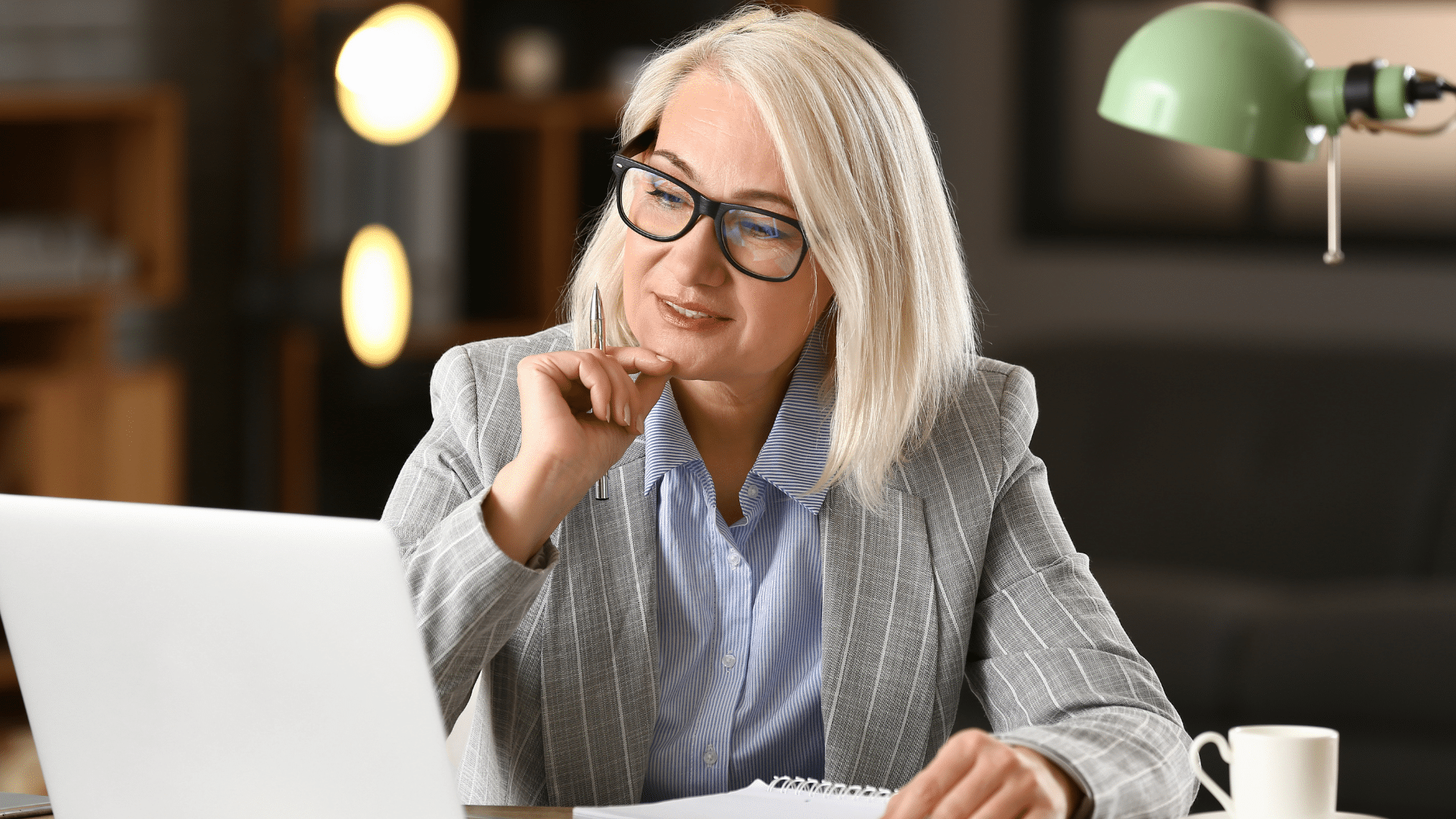 Femme sur un bureau devant un écran d'ordinateur qui réfléchit à comment se démarquer des autres candidats lors de sa recherche d’emploi