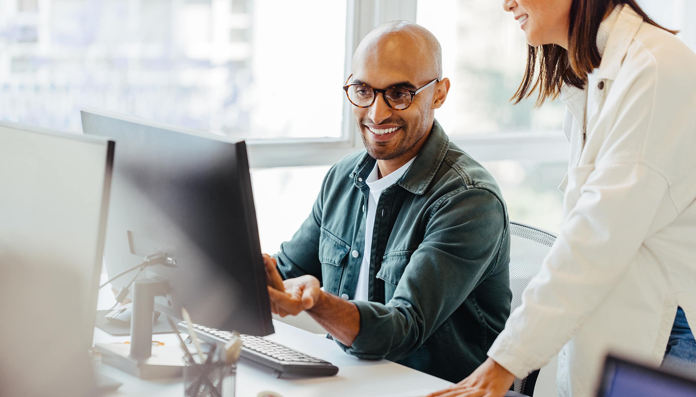 Deux personnes devant un ordinateur pour illustrer les meilleures pratiques pour rédiger un CV percutant.
